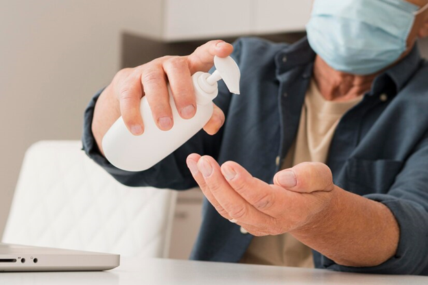 A man using antiseptic liquid to clean his hands